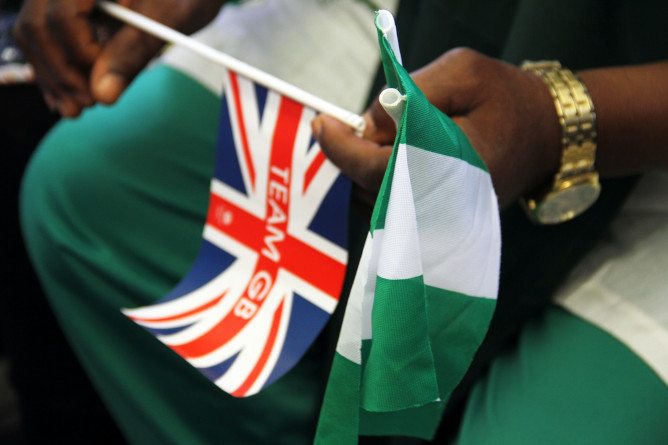 A football fan holds two flags to support Great Britain and Nigeria.
